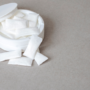 white container with nicotine pouches on plain grey surface